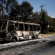 Men walk past a bus that was torched during protests in the town of Sebeta, Oromia region, Ethiopia.